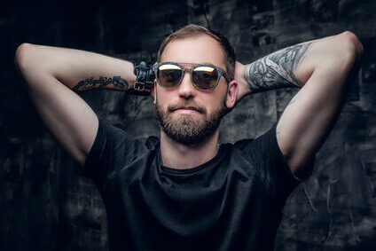 A man in sunglasses with tattoo on his arm